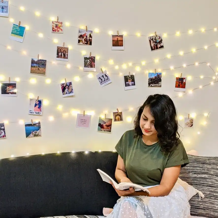 Polaroid prints hung with lights and clips for decor on the wall