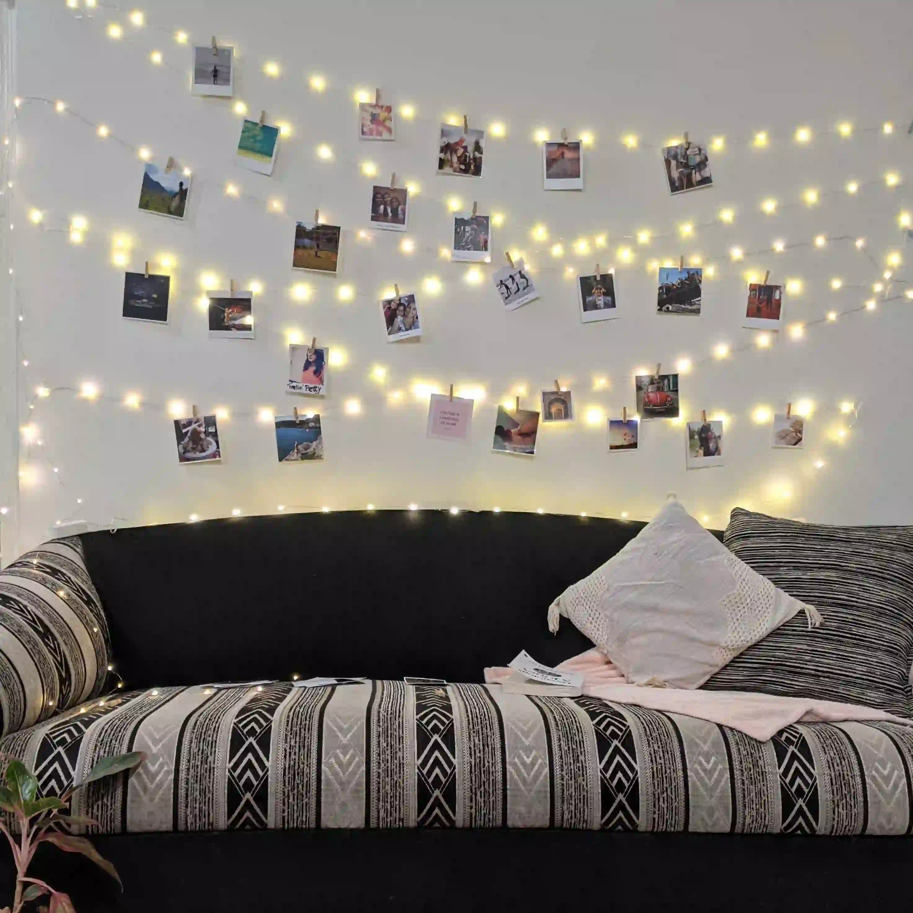 Polaroids hanging on wall with lights